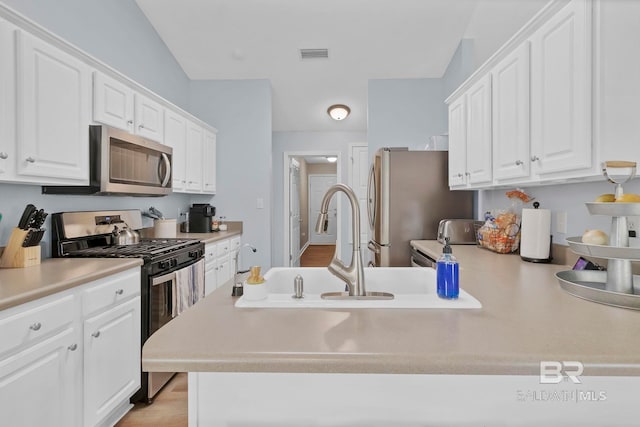 kitchen with white cabinets, appliances with stainless steel finishes, and visible vents