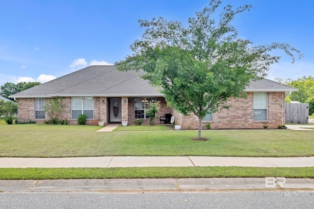 ranch-style house featuring brick siding, a shingled roof, and a front yard
