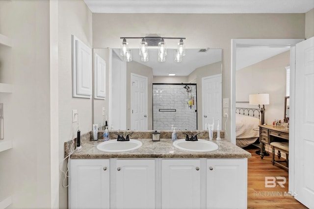 full bath featuring visible vents, a sink, connected bathroom, and a stall shower