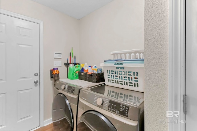 clothes washing area with separate washer and dryer, laundry area, and wood finished floors