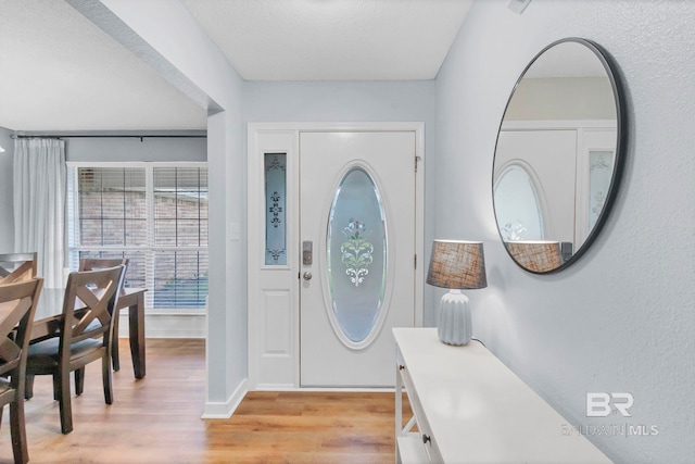 foyer with baseboards and light wood-style flooring