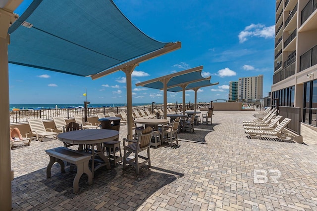 view of patio with a water view and a view of the beach