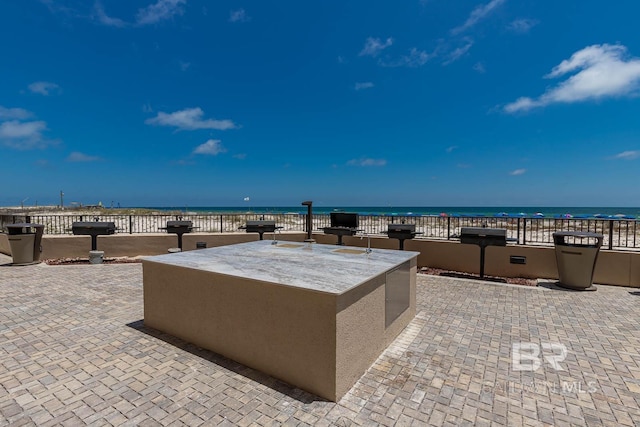 view of patio with a water view and area for grilling