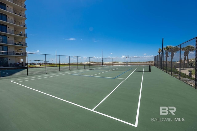 view of tennis court with basketball hoop