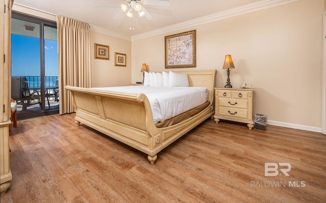 bedroom featuring hardwood / wood-style floors, a wall of windows, ornamental molding, access to exterior, and ceiling fan