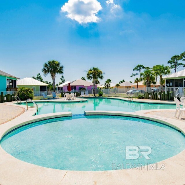 pool with a patio and fence