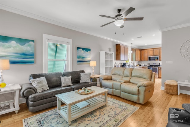 living room with ceiling fan, baseboards, light wood finished floors, ornamental molding, and recessed lighting