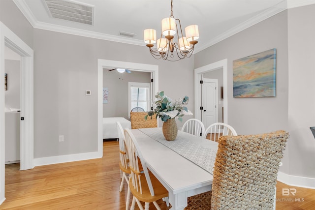 dining space with light wood-style floors, baseboards, crown molding, and visible vents