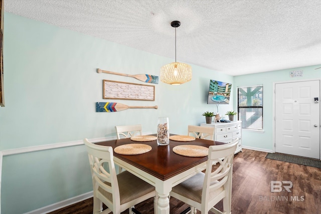 dining room with dark hardwood / wood-style floors and a textured ceiling