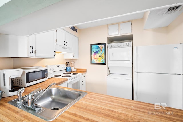 kitchen featuring light wood-type flooring, white appliances, sink, white cabinetry, and stacked washing maching and dryer