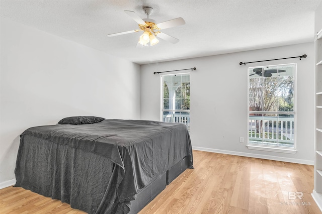 bedroom with multiple windows, ceiling fan, and light hardwood / wood-style flooring