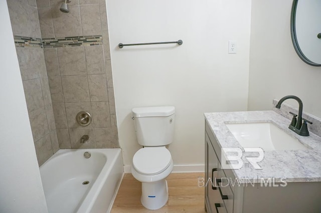 full bathroom with tiled shower / bath, hardwood / wood-style flooring, vanity, and toilet