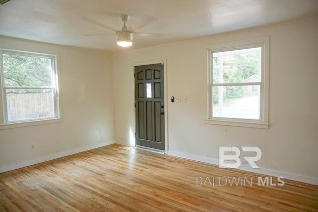 empty room with ceiling fan and light hardwood / wood-style flooring