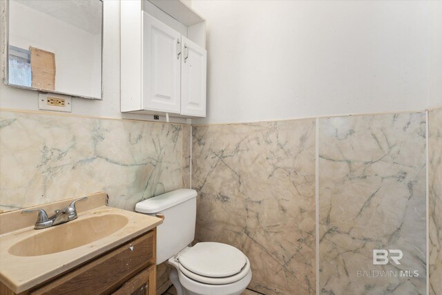672 Burden St, Mobile, AL 36607 - bathroom featuring toilet, tile walls, vanity, and wainscoting