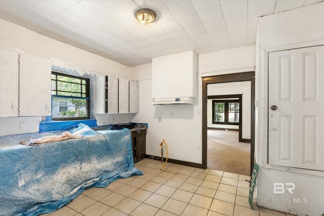 672 Burden St, Mobile, AL 36607 - kitchen with healthy amount of natural light, light tile patterned floors, white cabinets, and baseboards