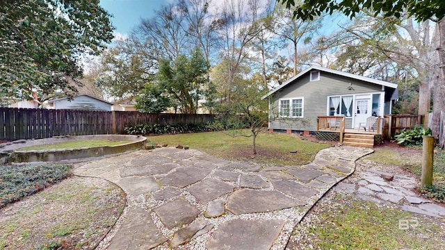 rear view of house with a deck, a lawn, a patio, and a fenced backyard