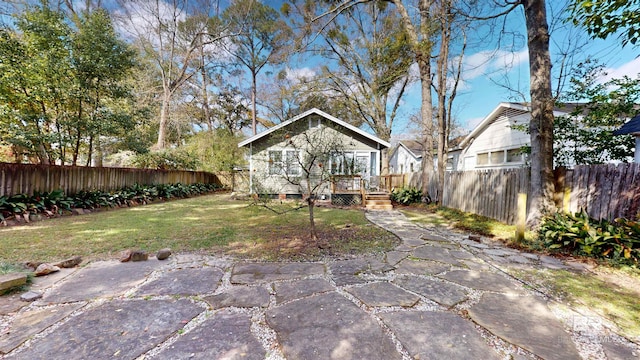 back of house featuring a fenced backyard and a yard