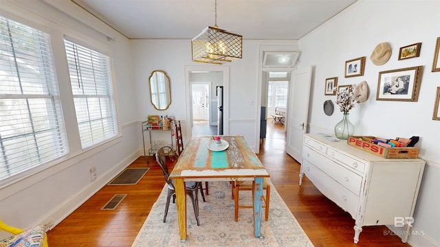 dining area featuring visible vents, baseboards, and wood finished floors