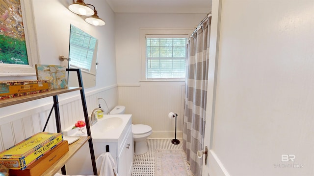 bathroom featuring wainscoting, toilet, vanity, and a shower with curtain