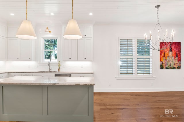 kitchen featuring light wood-type flooring, backsplash, sink, and pendant lighting