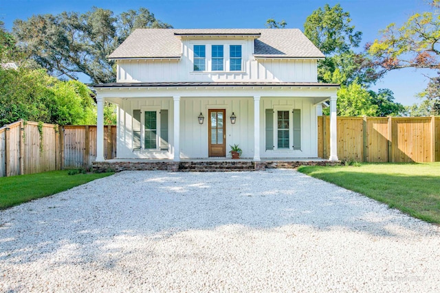 modern inspired farmhouse with covered porch and a front yard