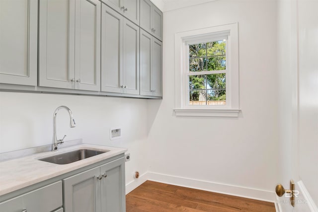 washroom with dark hardwood / wood-style flooring, washer hookup, electric dryer hookup, cabinets, and sink