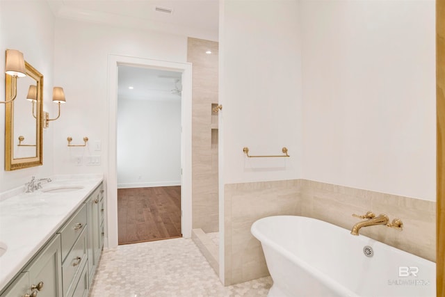 bathroom with hardwood / wood-style flooring, a bathing tub, vanity, tile walls, and ceiling fan