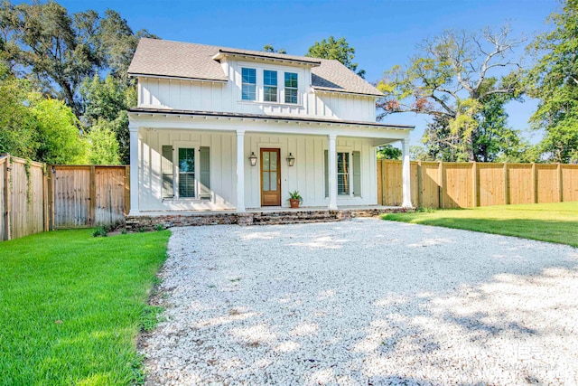 modern farmhouse with a front lawn and covered porch