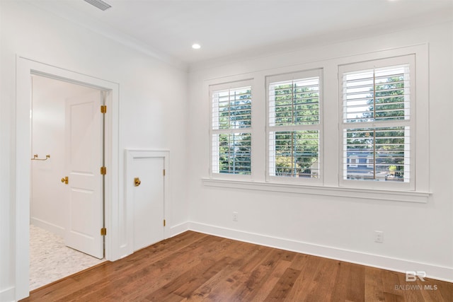 unfurnished room with wood-type flooring, plenty of natural light, and ornamental molding