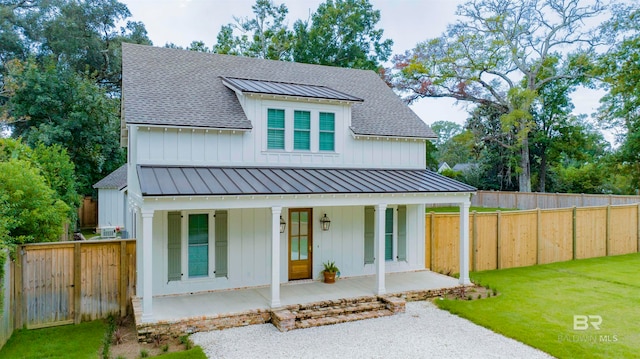 modern farmhouse featuring a porch and a front lawn