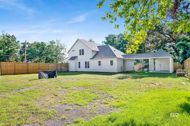 rear view of house featuring a lawn