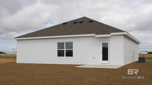 8992 Chabo Cir, Foley, AL 36535 - back of house featuring a shingled roof, central AC unit, brick siding, and a yard