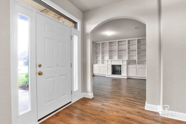 entryway with dark hardwood / wood-style flooring and a healthy amount of sunlight