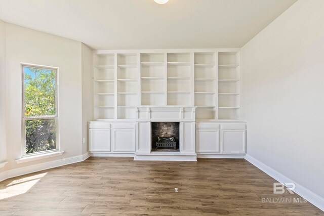 spare room with ornamental molding, a raised ceiling, hardwood / wood-style floors, and a notable chandelier