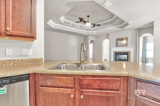 kitchen featuring crown molding, dishwasher, sink, ceiling fan, and a raised ceiling