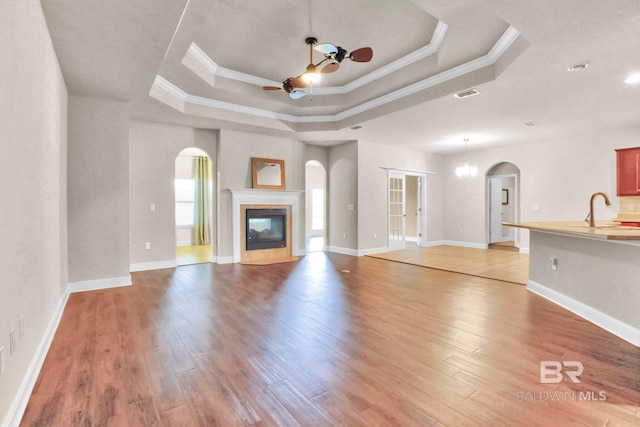 unfurnished living room with light wood-type flooring, ceiling fan, and ornamental molding