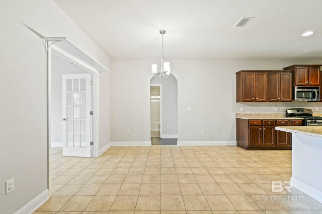 unfurnished room featuring a textured ceiling, ceiling fan, and light tile patterned flooring