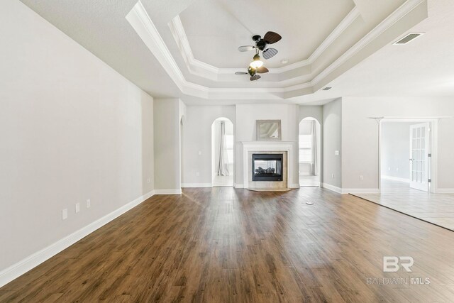 spare room featuring crown molding, ceiling fan, wood-type flooring, and a tray ceiling