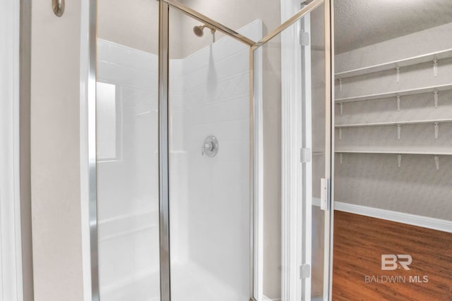 bathroom with wood-type flooring and an enclosed shower