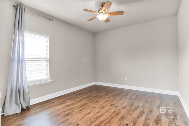 spare room featuring dark wood-type flooring and ceiling fan