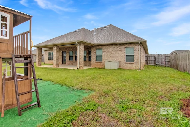 rear view of property with a lawn and a patio