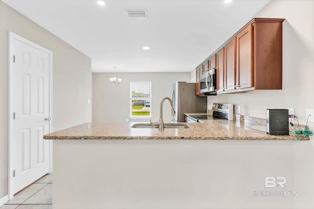 15030 Marem Dr, Foley, AL 36535 - kitchen with stainless steel appliances, a peninsula, brown cabinets, light stone counters, and recessed lighting