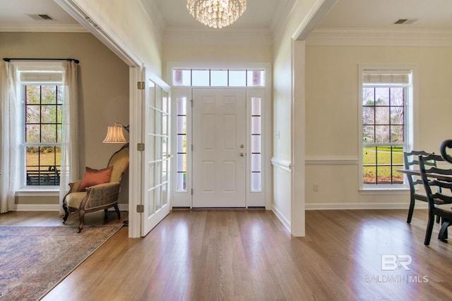 entryway with hardwood / wood-style flooring and crown molding