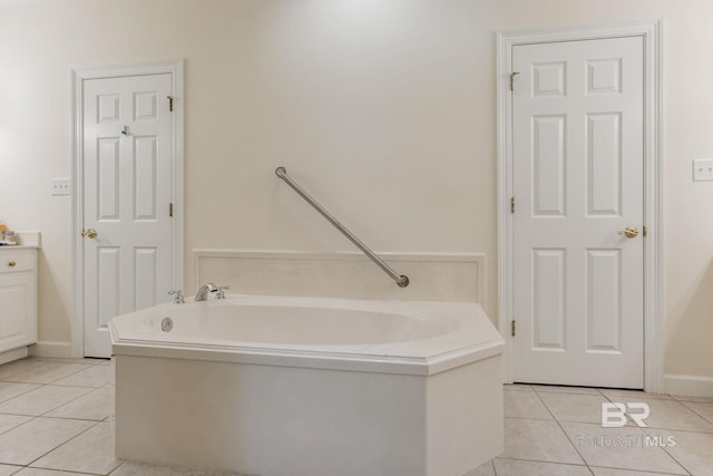 bathroom featuring a tub to relax in, vanity, and tile patterned flooring