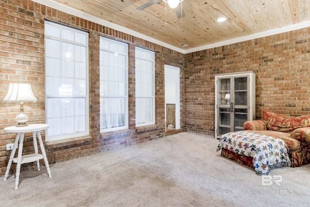 unfurnished room featuring carpet floors, ceiling fan, brick wall, and wood ceiling