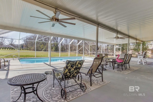 view of swimming pool featuring a patio area, ceiling fan, and glass enclosure
