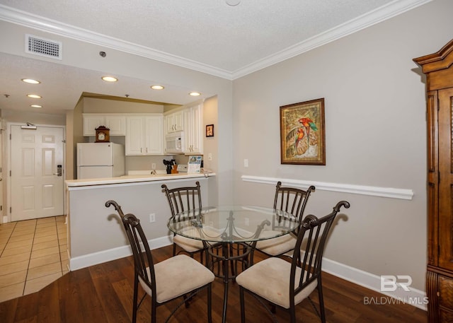 22984 Perdido Beach Blvd Unit A23, Orange Beach, AL 36561 - dining room featuring crown molding, wood finished floors, baseboards, a textured ceiling, and recessed lighting