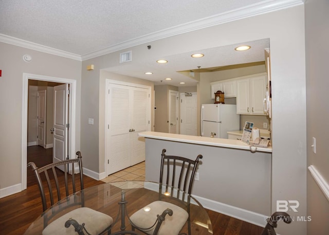 22984 Perdido Beach Blvd Unit A23, Orange Beach, AL 36561 - dining area with crown molding, light wood-style flooring, a textured ceiling, baseboards, and recessed lighting