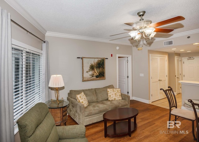 22984 Perdido Beach Blvd Unit A23, Orange Beach, AL 36561 - living room with ceiling fan, ornamental molding, a textured ceiling, wood finished floors, and baseboards