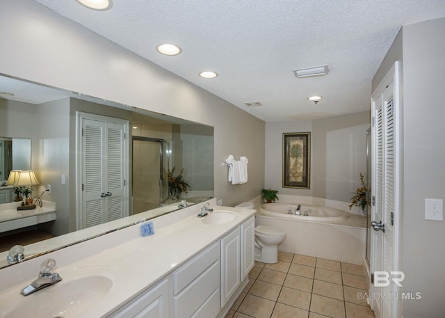 22984 Perdido Beach Blvd Unit A23, Orange Beach, AL 36561 - full bathroom featuring a closet, a garden tub, double vanity, tile patterned floors, and a textured ceiling